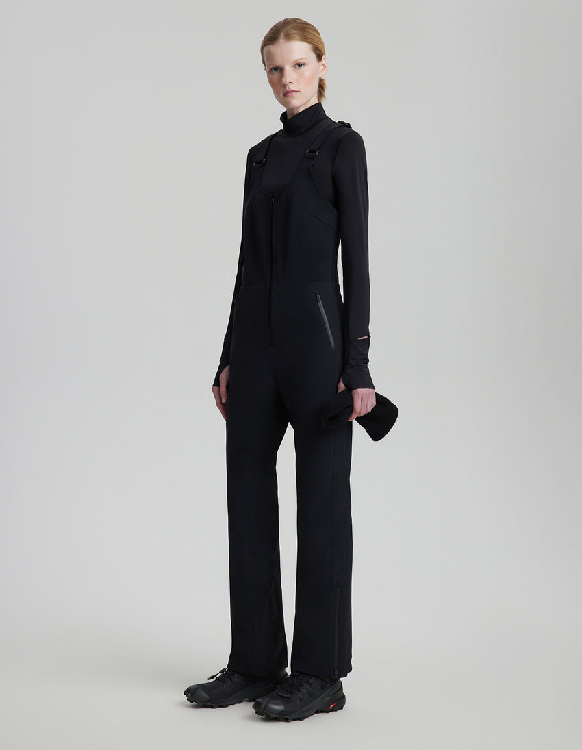 Person wearing a black outfit on a plain background